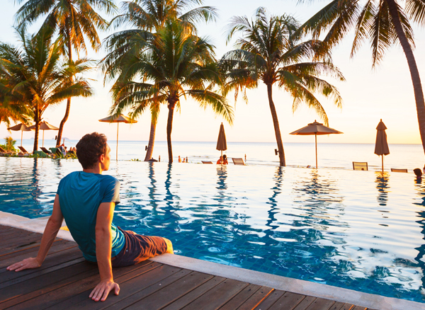 Hotel deals - man sitting by the edge of a pool