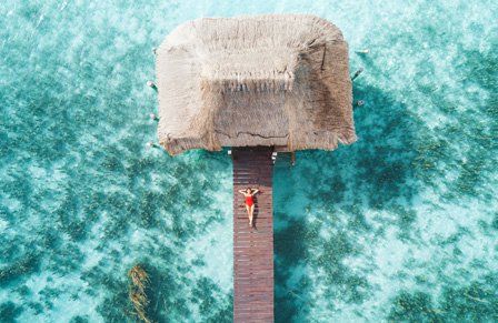 Woman lying on a deck by the ocean