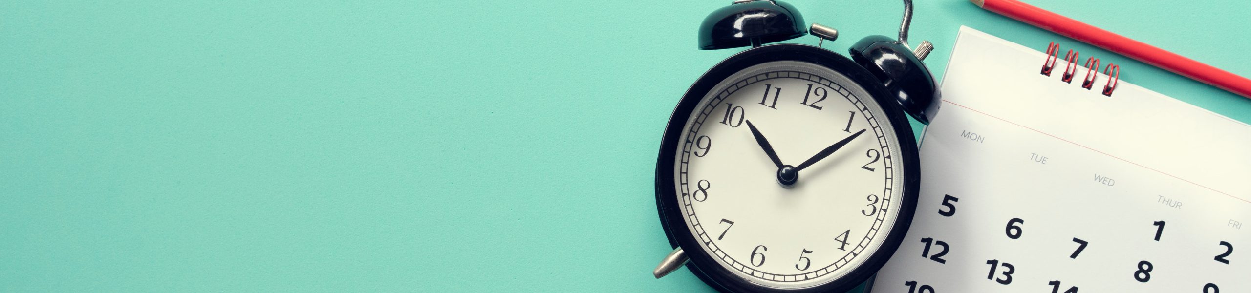 Alarm clock sitting beside calendar